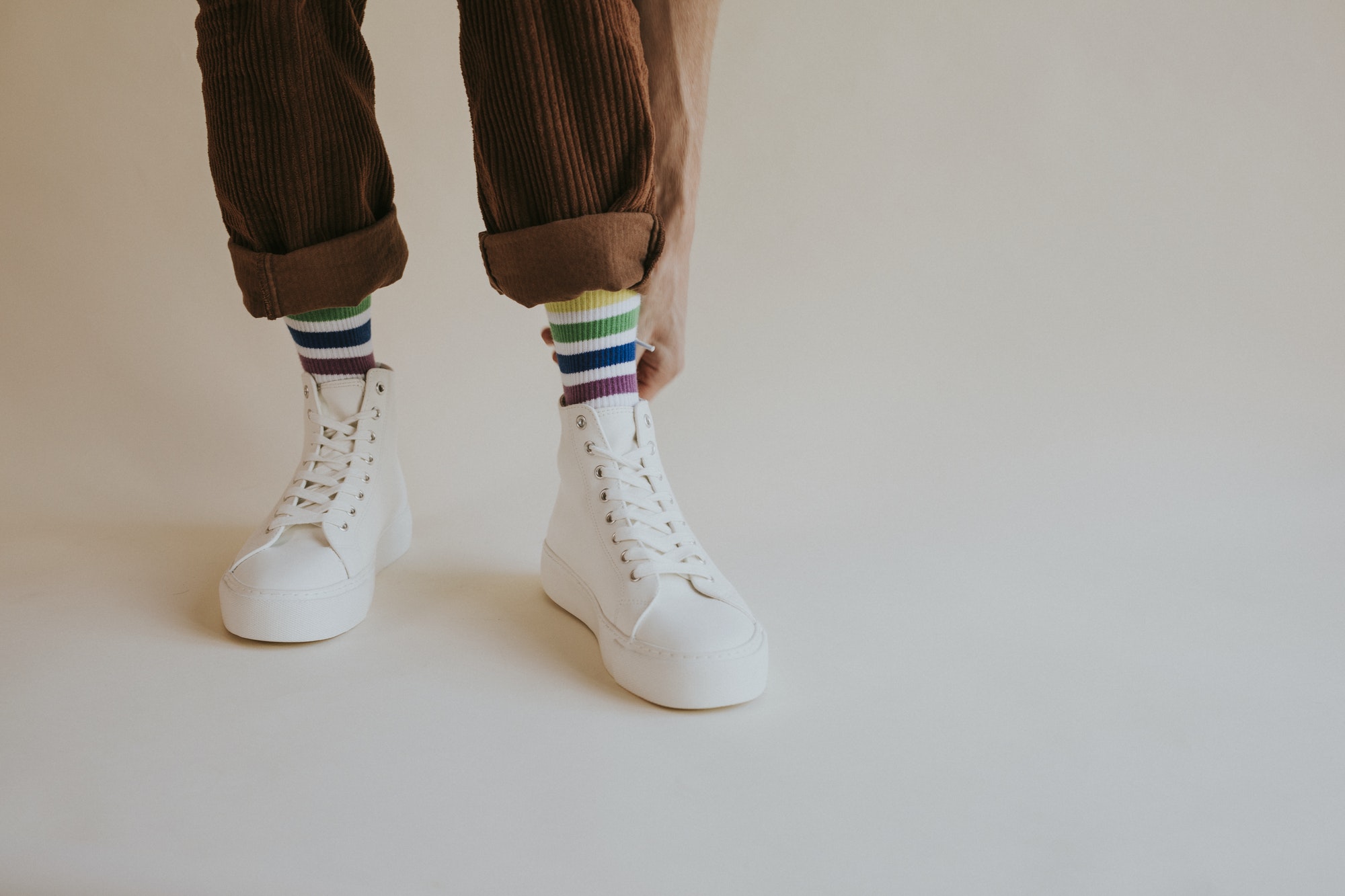 man-putting-on-high-top-sneakers-studio-shoot.jpg